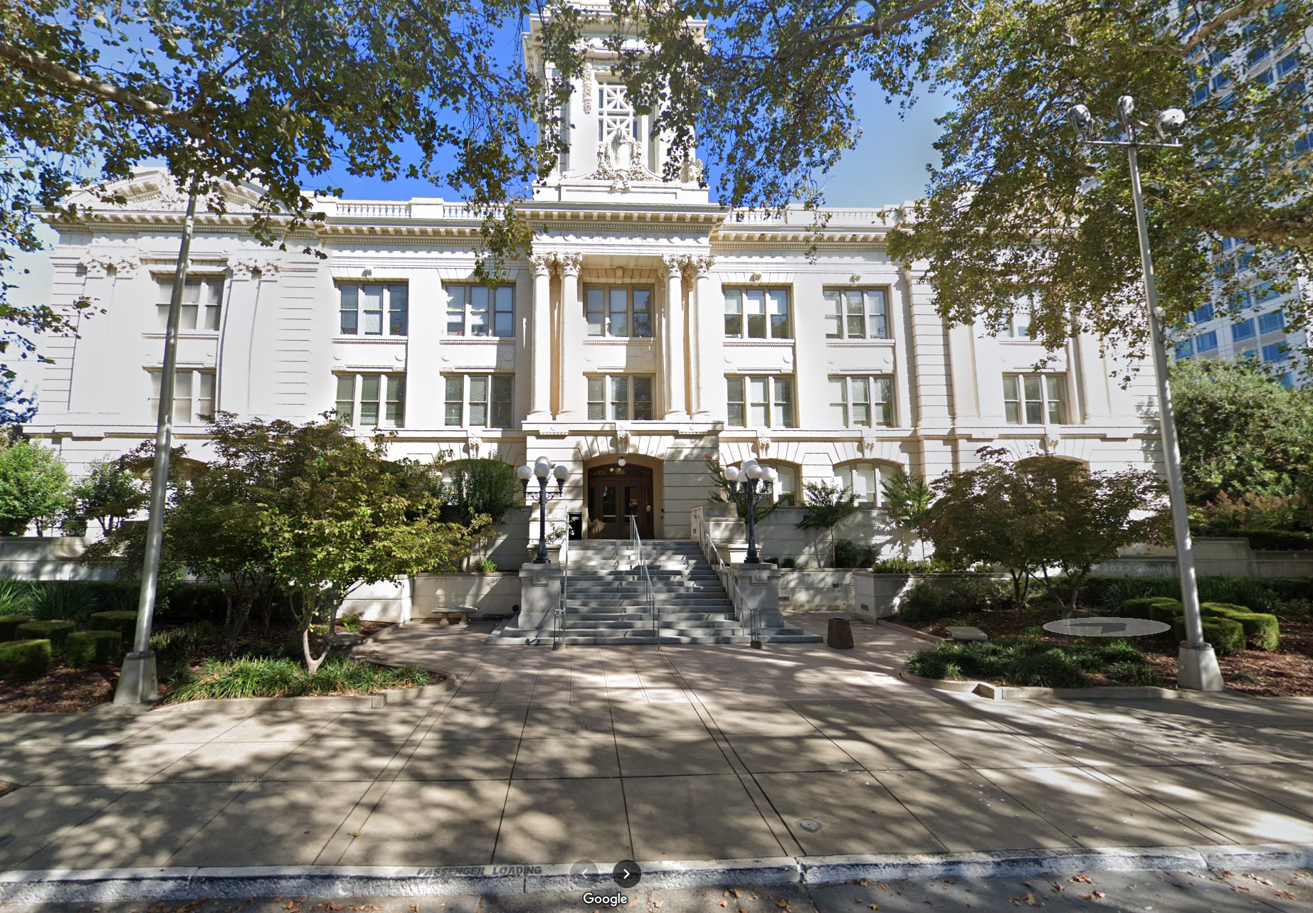 Photo of entrance to Sacramento Historic City Hall. A large white building with steps leading up to double doors.